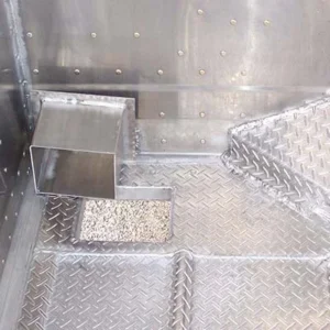 Drop-box-style drain in the corner of the trailer